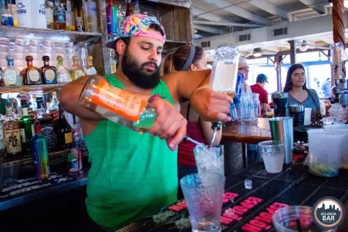 Bartender pouring drinks with two hands